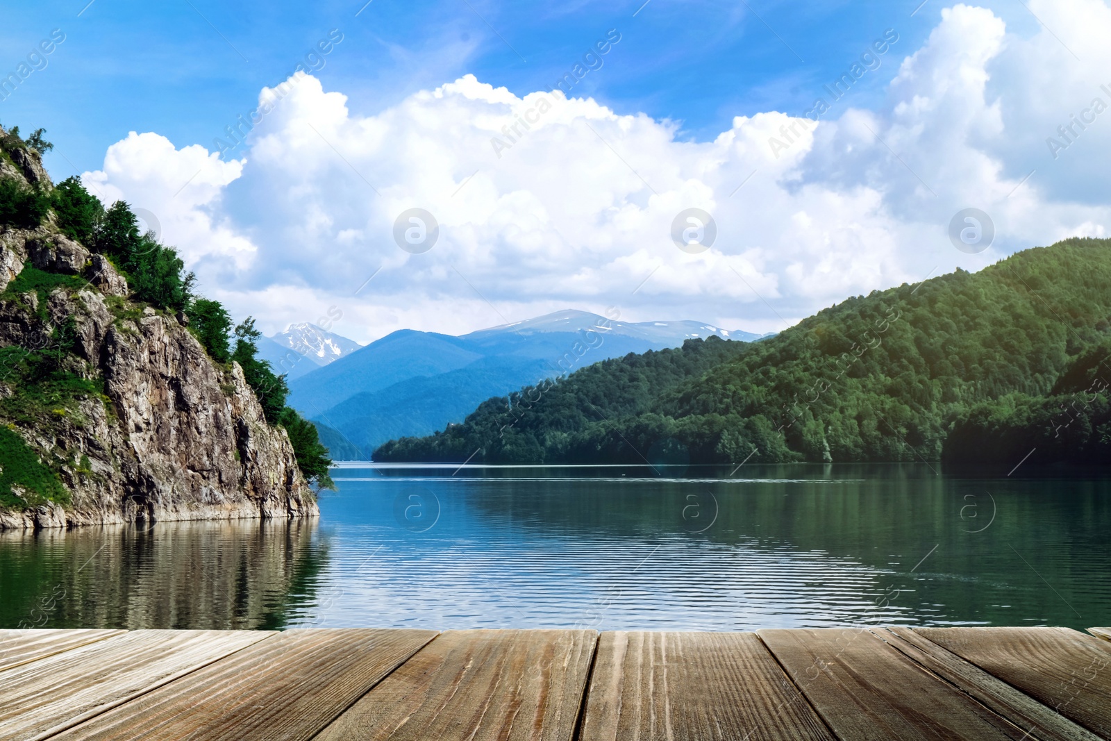 Image of Beautiful view of mountains and wooden pier near river on sunny day