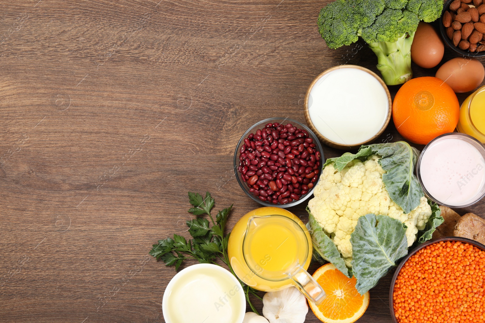 Photo of Set of natural food high in calcium on wooden table, flat lay. Space for text