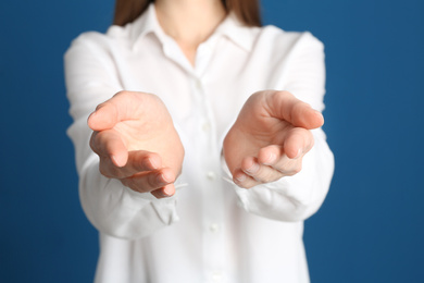Photo of Young woman against blue background, focus on hands