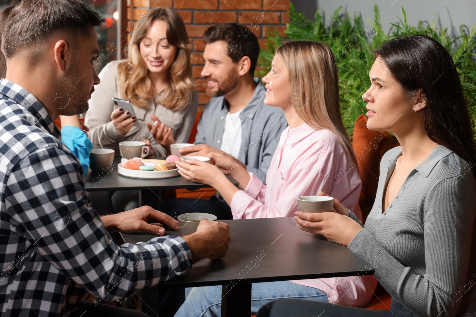 Photo of Friends with coffee spending time together in cafe