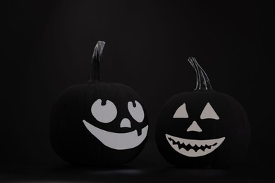Photo of Halloween celebration. Pumpkins with drawn faces on table in darkness