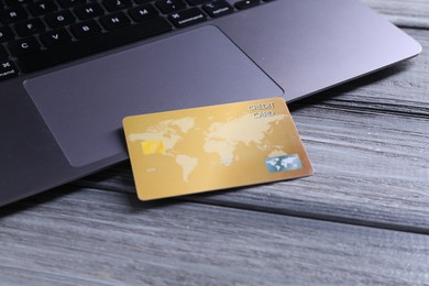 Credit card and laptop on grey wooden table