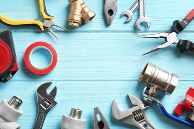 Flat lay composition with plumber's tools and space for text on wooden background