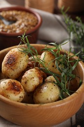 Delicious grilled potatoes with tarragon in bowl on table, closeup