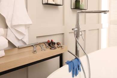 Photo of Professional plumbing tools and installed water tap in bathroom