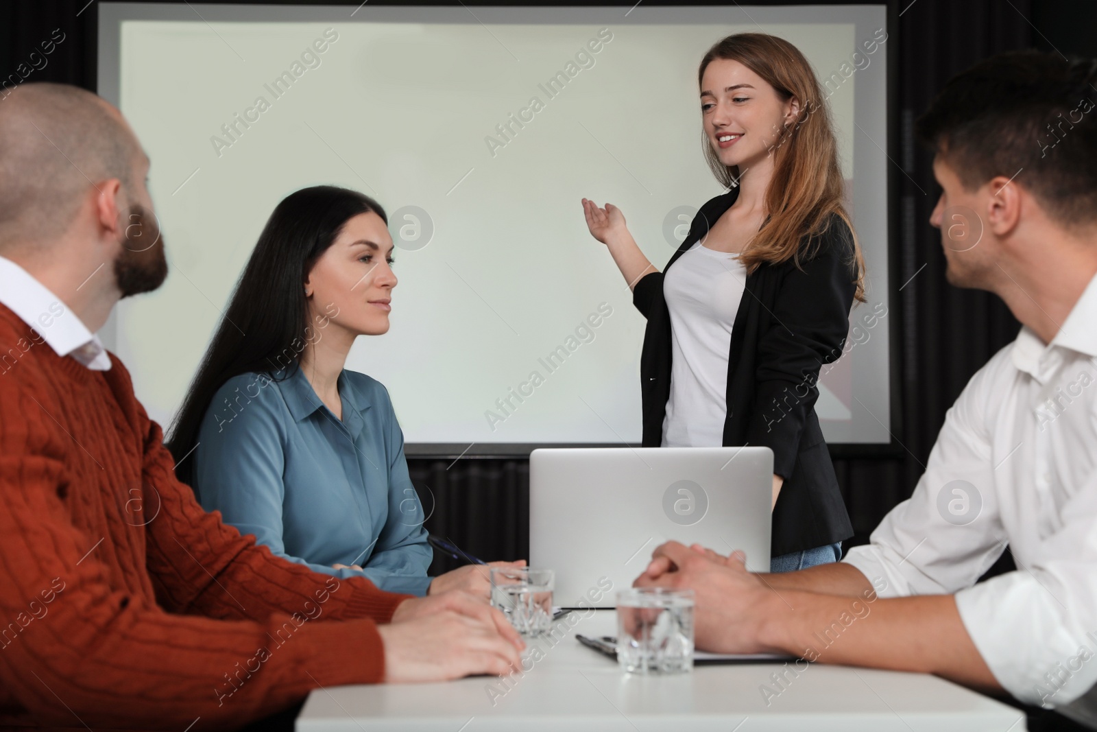 Photo of Business people having meeting in conference room with video projection screen