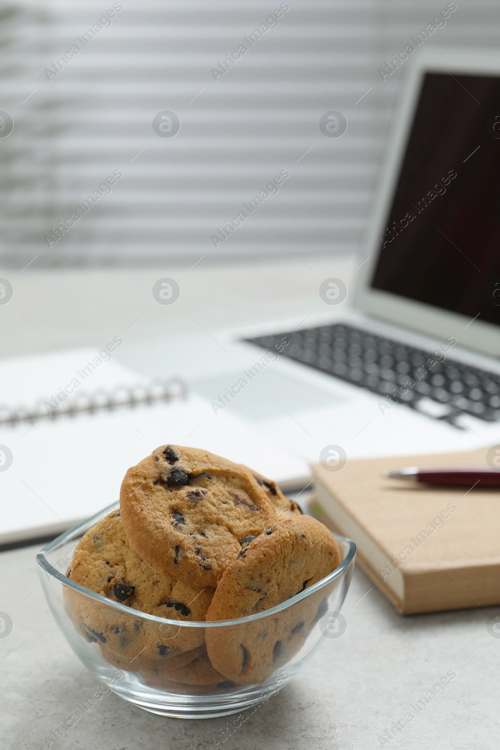 Photo of Chocolate chip cookies on light gray table in office