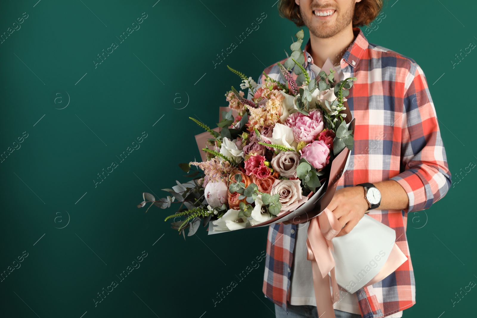 Photo of Man holding beautiful flower bouquet on green background, closeup. Space for text