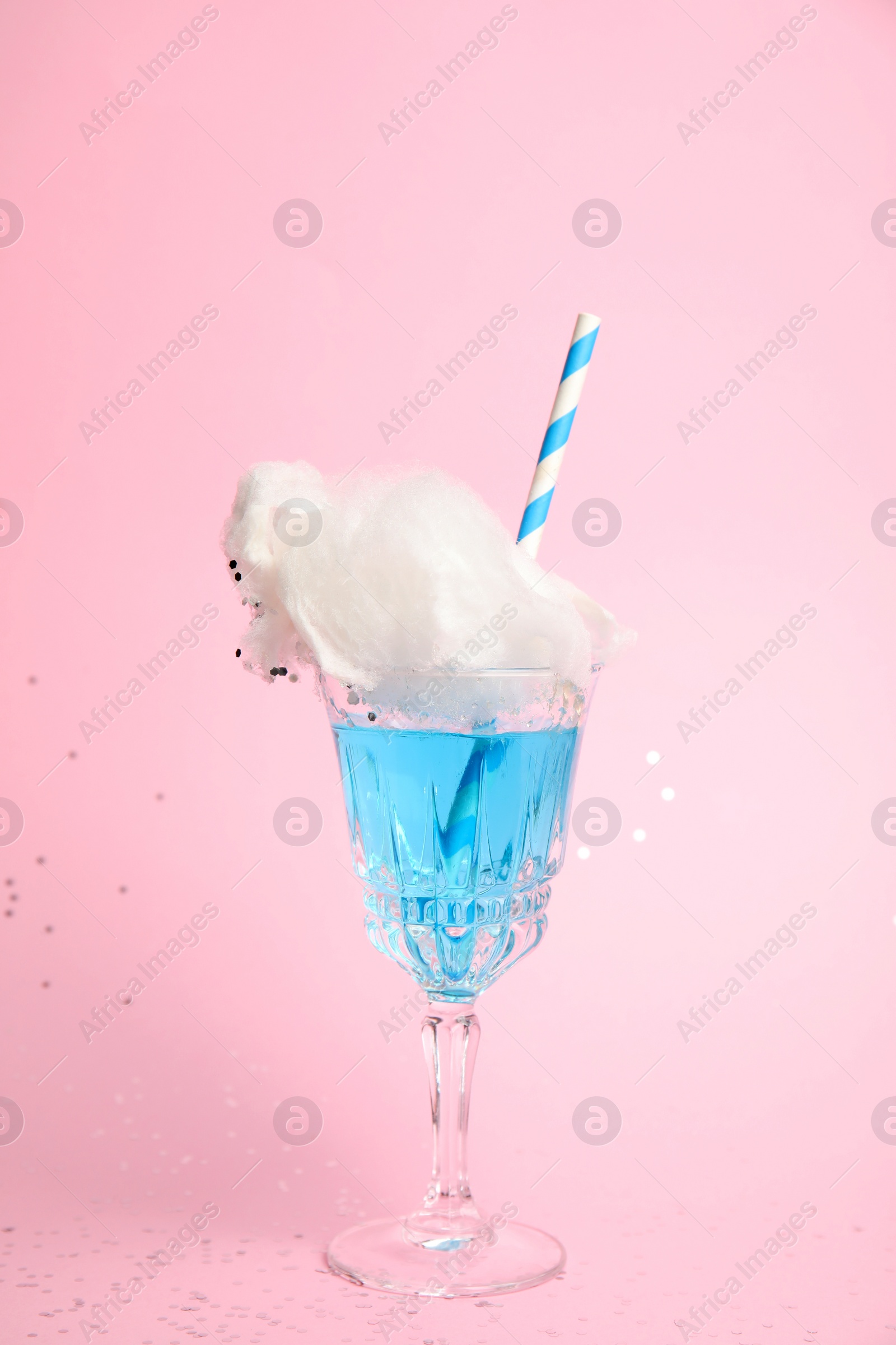 Photo of Cocktail with cotton candy in glass on pink background