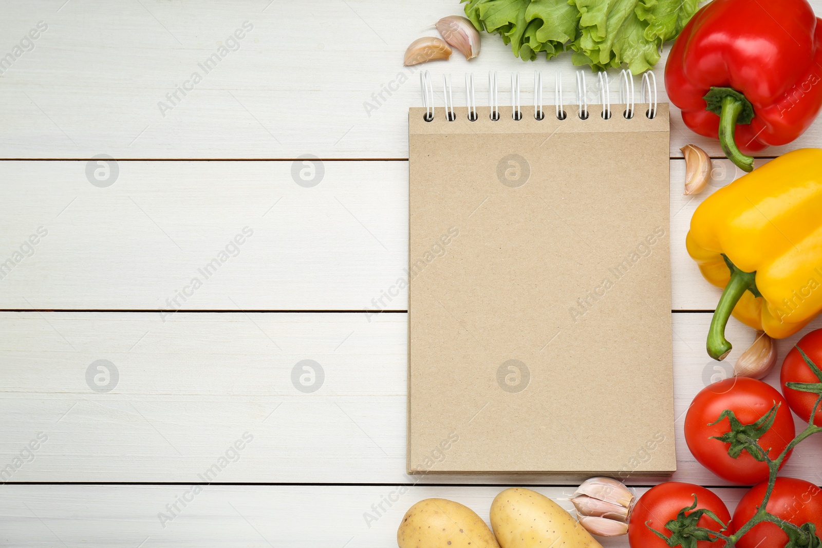 Photo of Blank recipe book and different ingredients on white wooden table, flat lay. Space for text