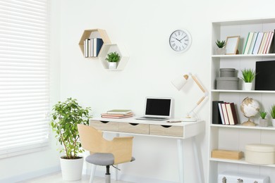 Beautiful workplace with comfortable desk and chair at home