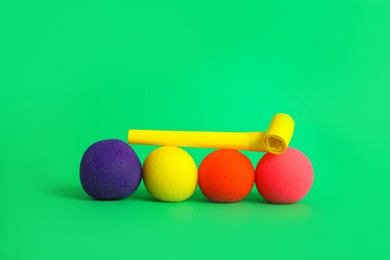 Clown noses and party blower on green background