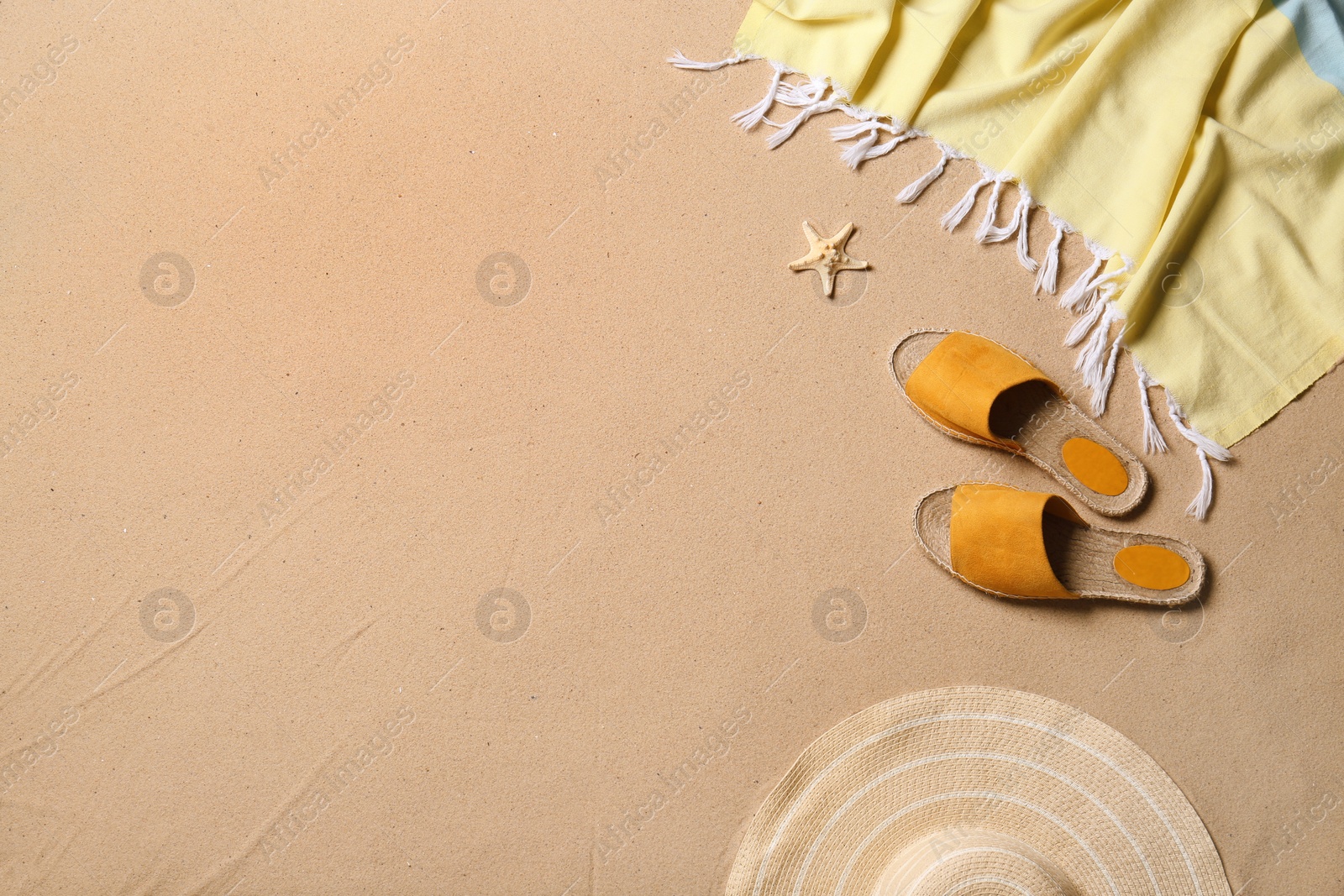 Photo of Flat lay composition with beach accessories and space for text on sand. Summer vacation