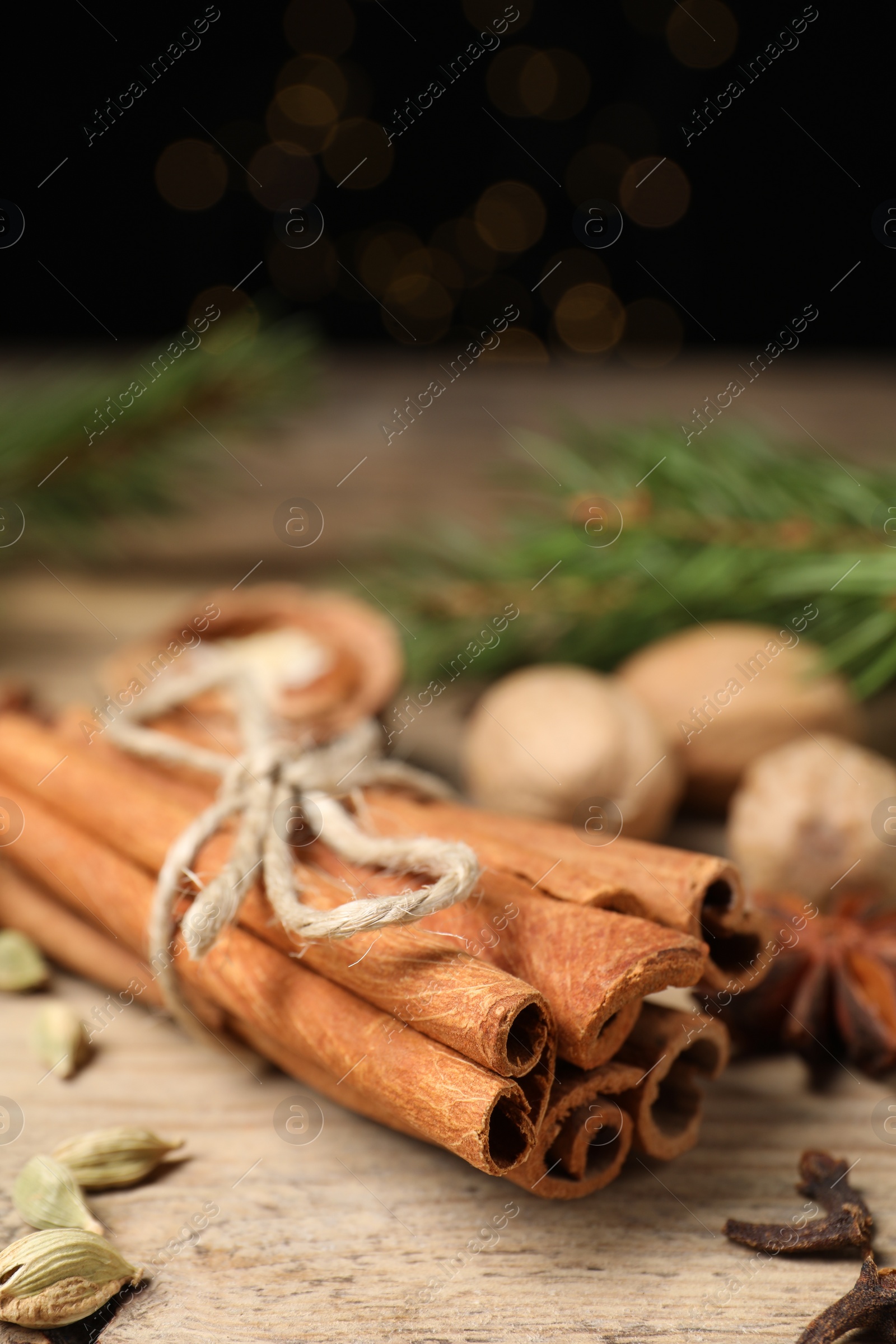 Photo of Cinnamon sticks and other spices on wooden table, closeup