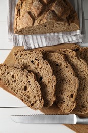 Photo of Freshly baked cut sourdough bread on white wooden table, top view