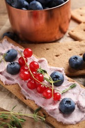 Photo of Tasty crispy crackers with cream cheese, thyme and berries, closeup
