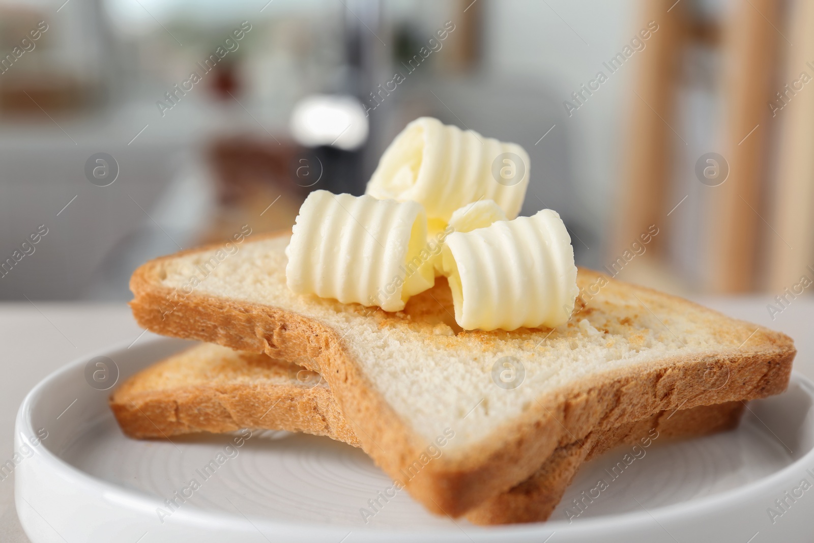 Photo of Plate with toasts and tasty butter curls, closeup