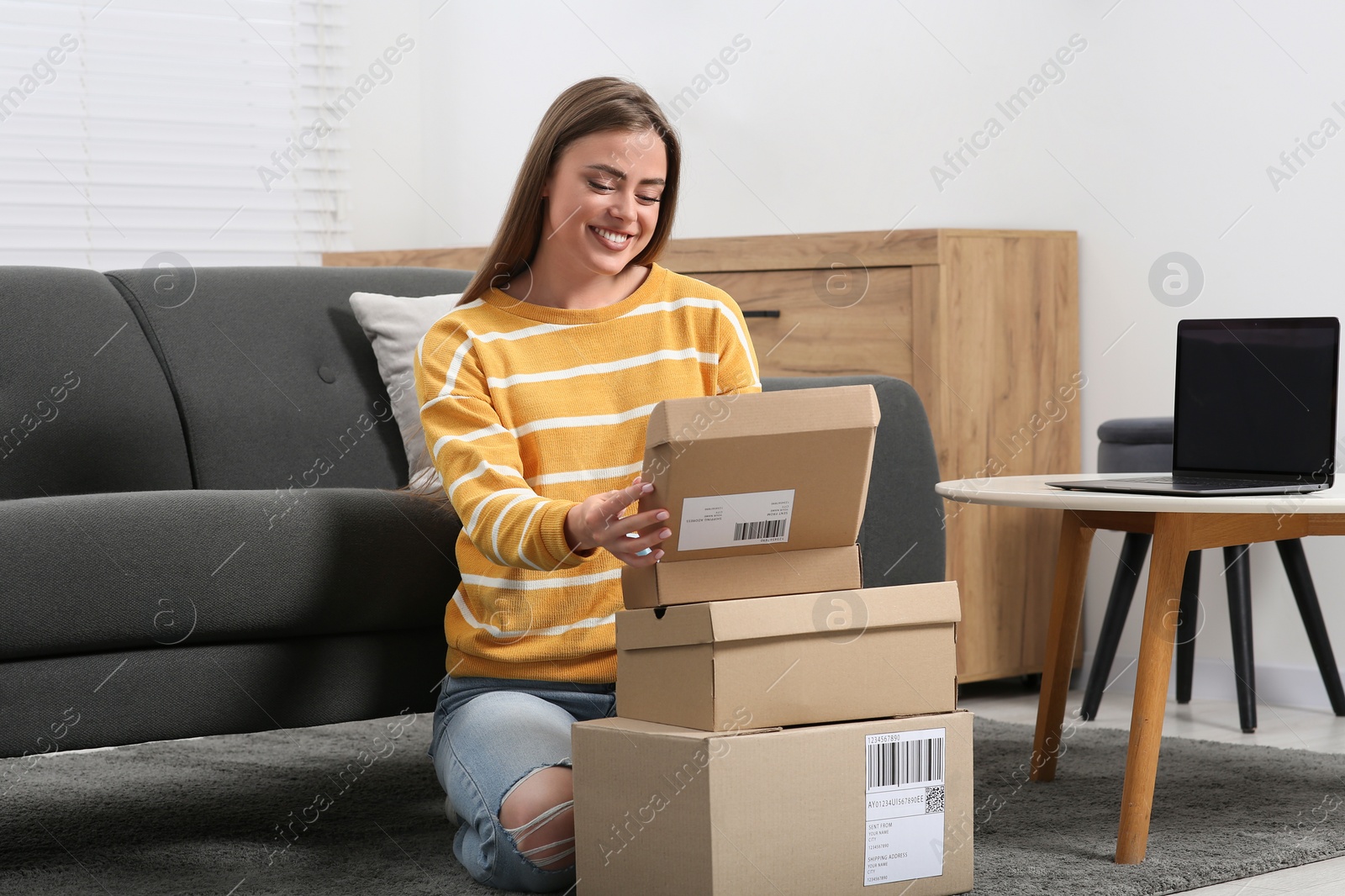 Photo of Happy woman with stack of parcels at home. Online store