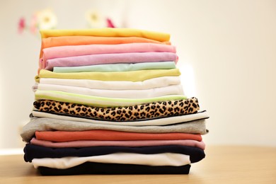Photo of Stack of clean clothes on wooden table