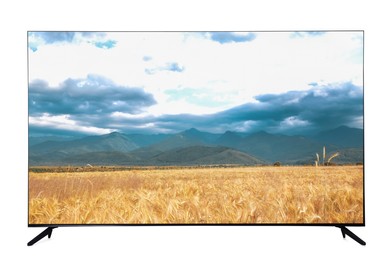 Modern wide screen TV monitor showing picturesque view of wheat field and cloudy sky isolated on white
