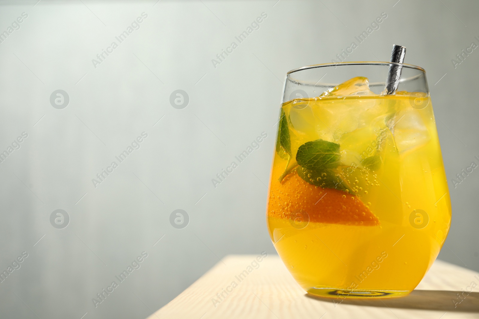 Photo of Delicious orange soda water on wooden table. Space for text