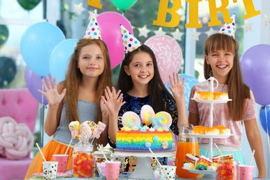 Happy children at birthday party in decorated room