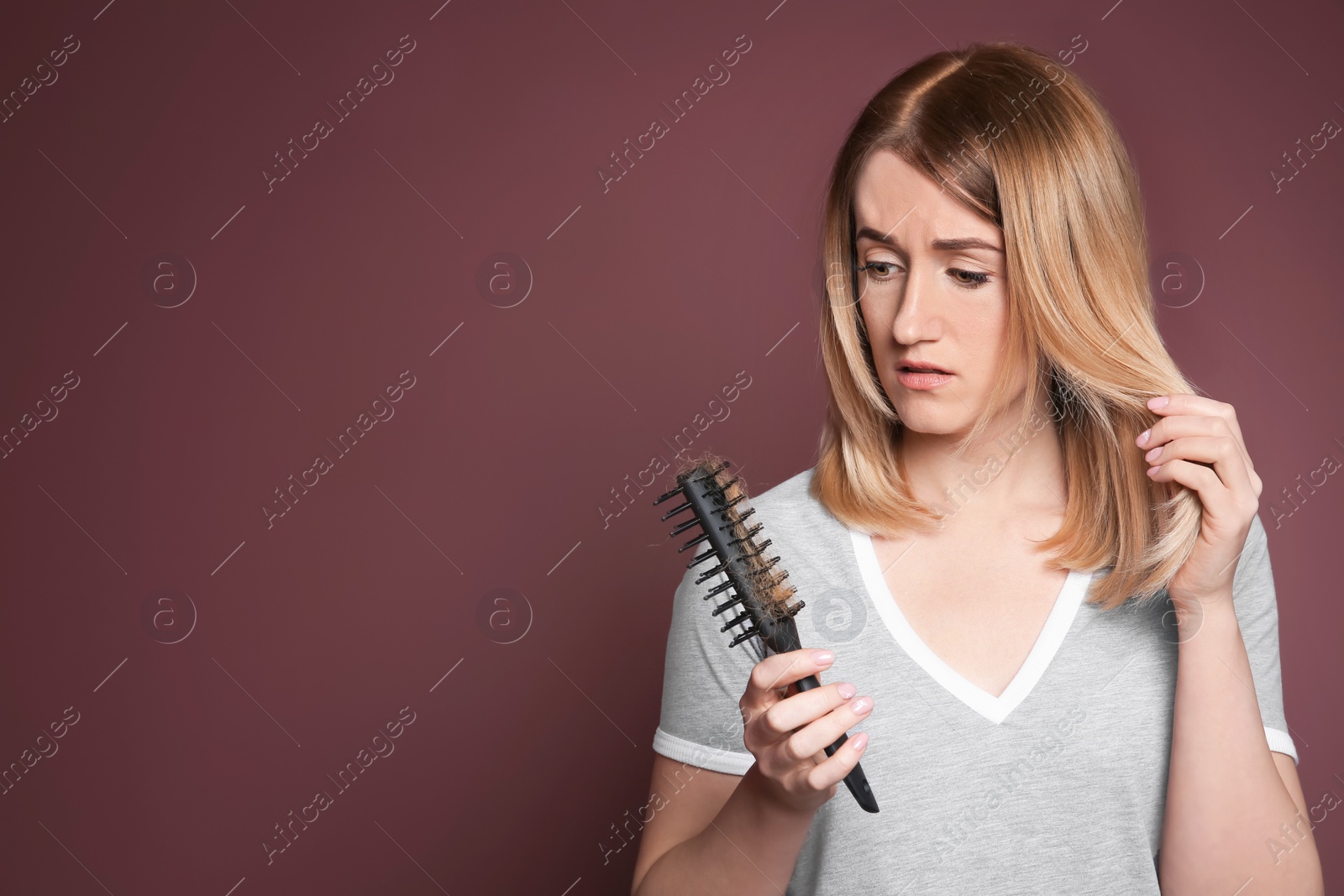 Photo of Young woman with hair loss problem on color background