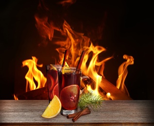 Mulled wine on wooden table near fireplace