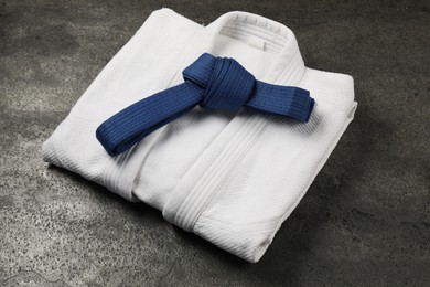 Photo of Blue karate belt and white kimono on gray background