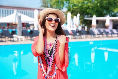 Photo of Beautiful young woman posing near outdoor swimming pool