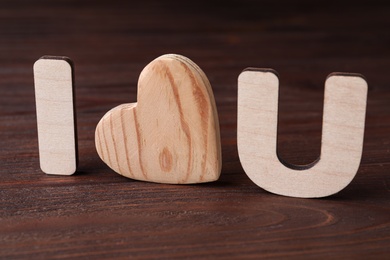 Phrase I Love You made of wooden letters and heart on table