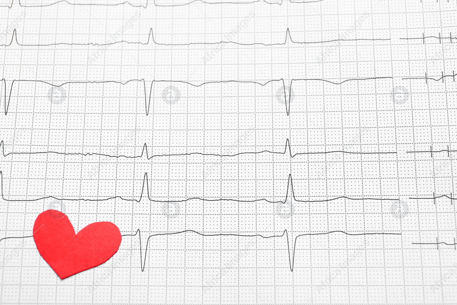 Photo of Red paper heart on cardiogram report, above view