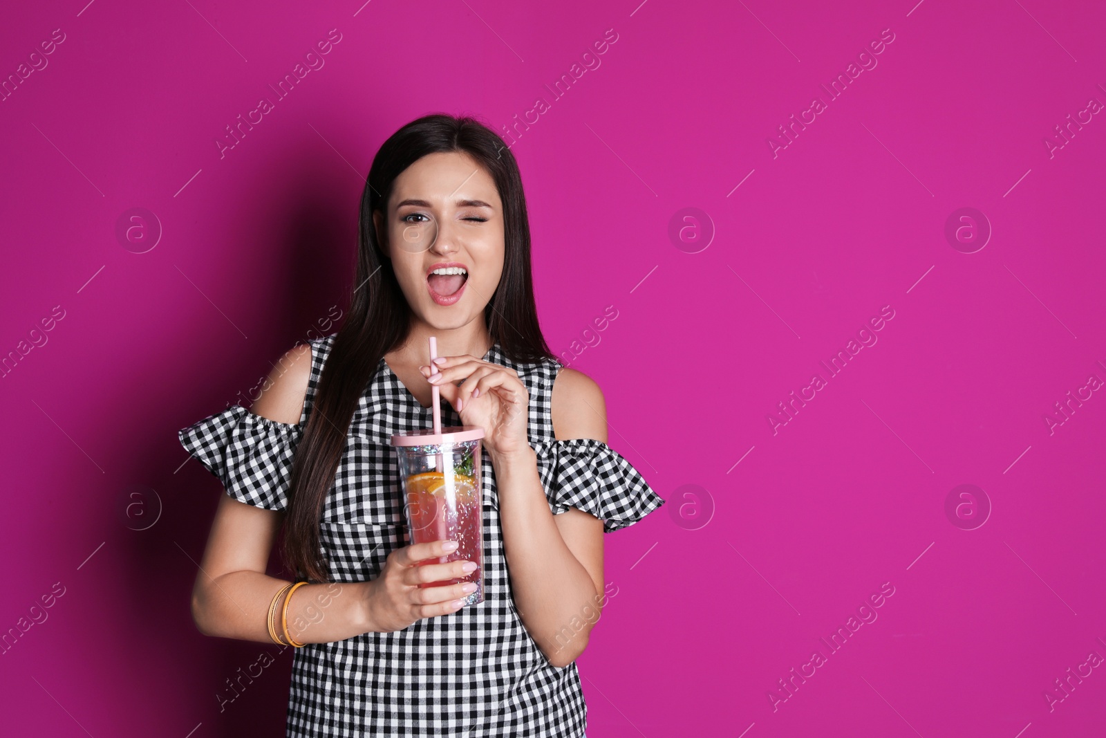 Photo of Young woman with tasty lemonade on color background. Natural detox drink