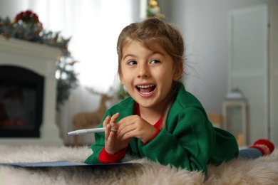 Cute child writing letter to Santa Claus at home. Christmas tradition