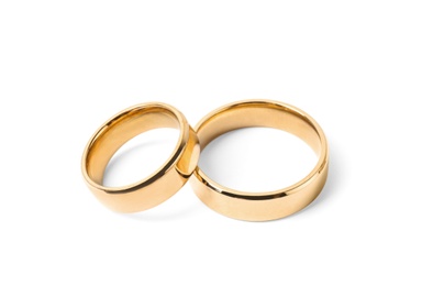 Shiny gold wedding rings on white background