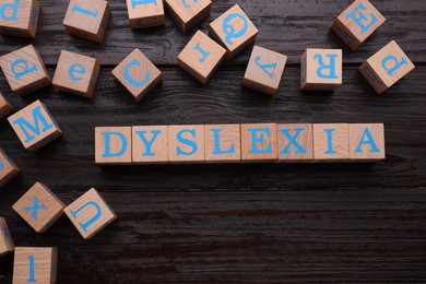 Cubes with word Dyslexia on wooden background, flat lay