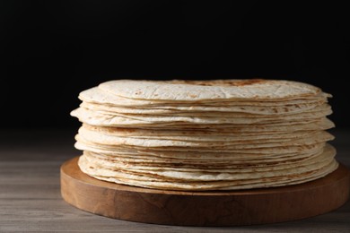 Photo of Many tasty homemade tortillas on wooden table