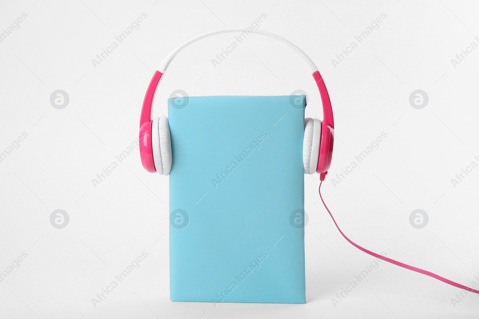Photo of Book with blank cover and headphones isolated on white