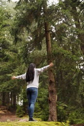 Woman on walk in beautiful coniferous forest