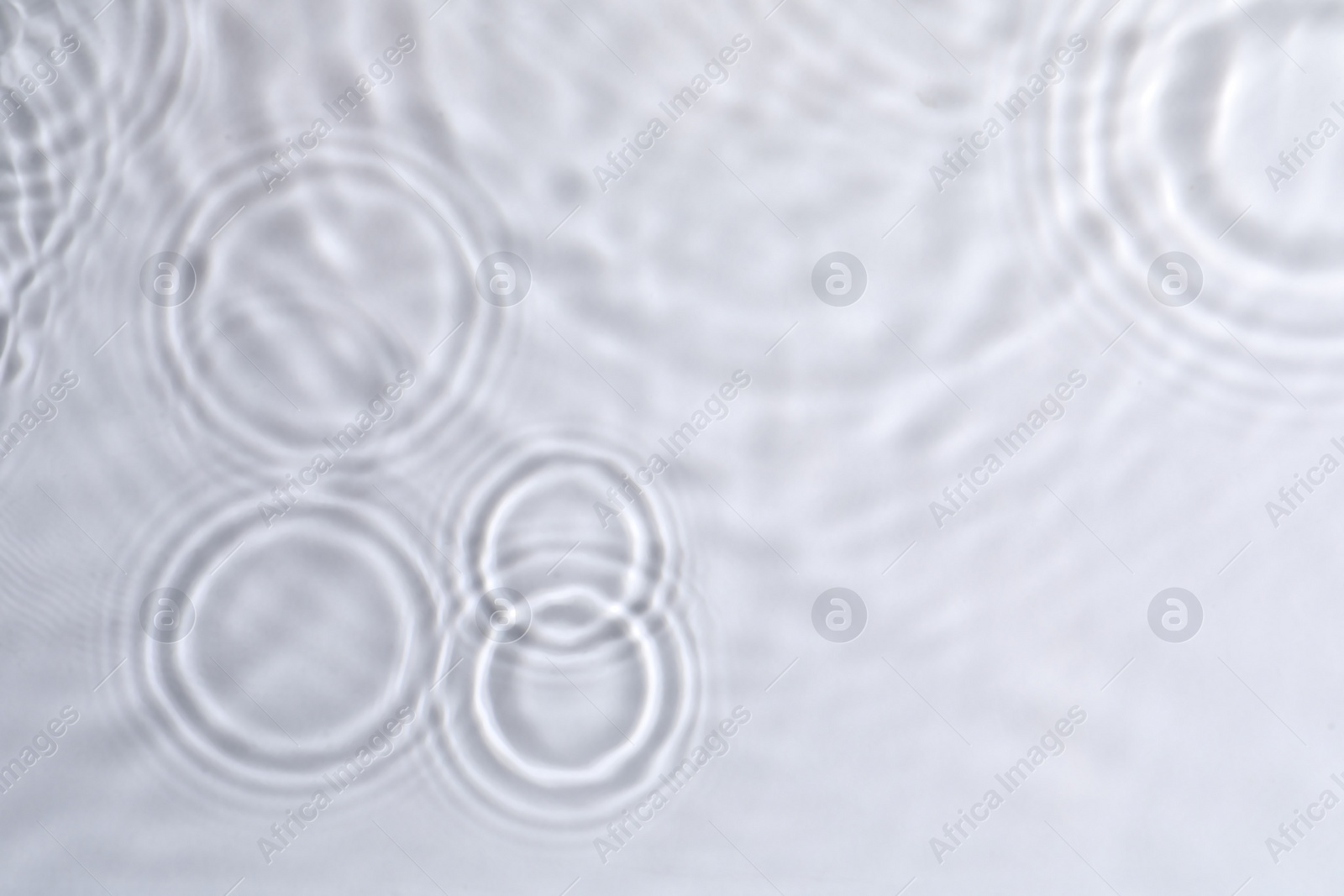 Photo of Closeup view of water with circles on light background