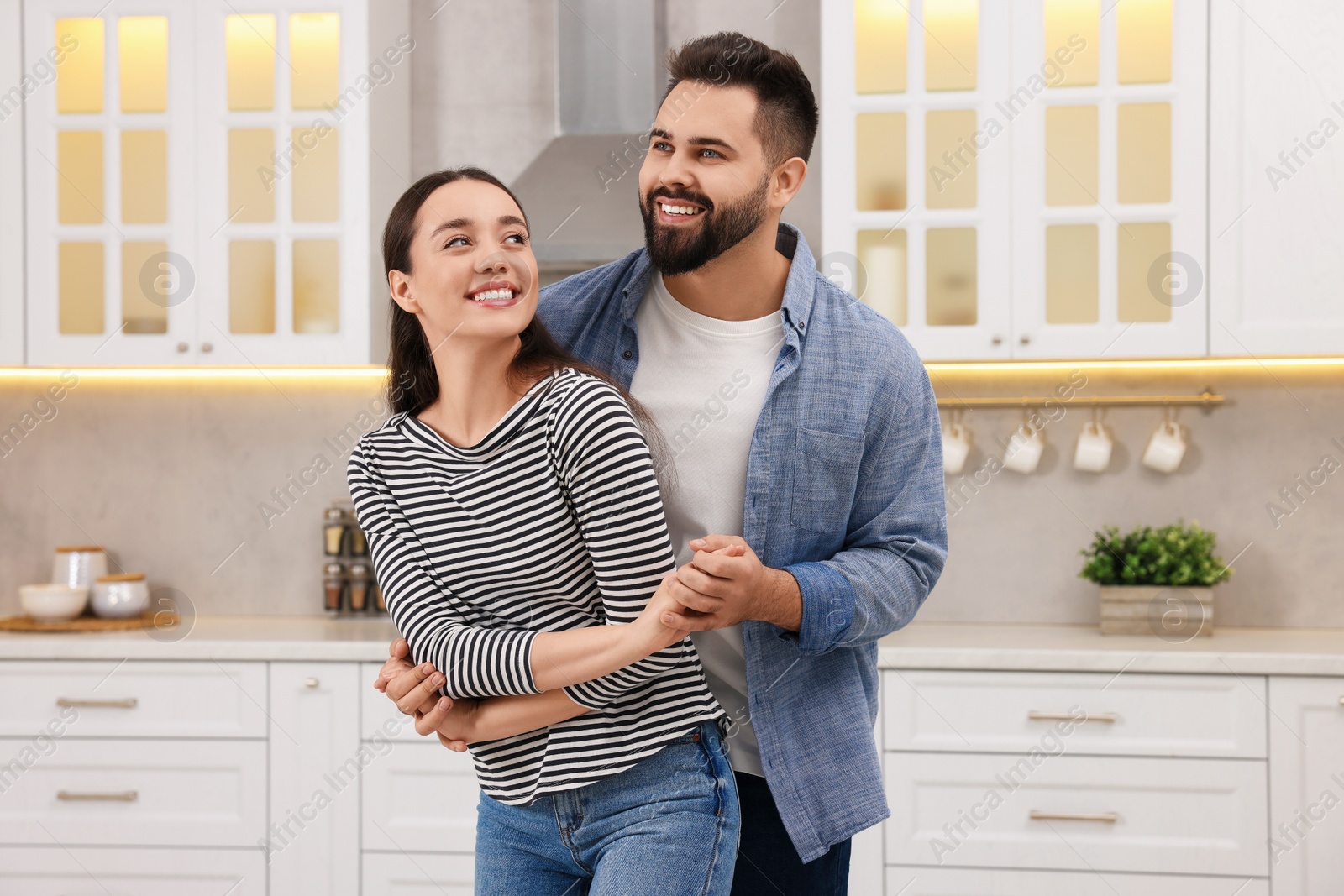 Photo of Happy lovely couple dancing together in kitchen