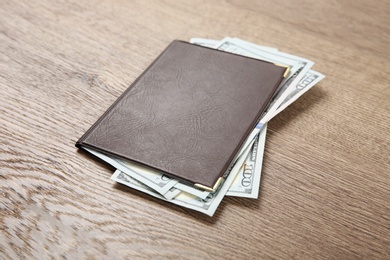 Photo of Pension certificate with American money on brown wooden background