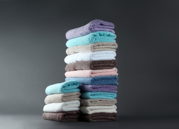 Photo of Different fresh soft terry towels on grey background