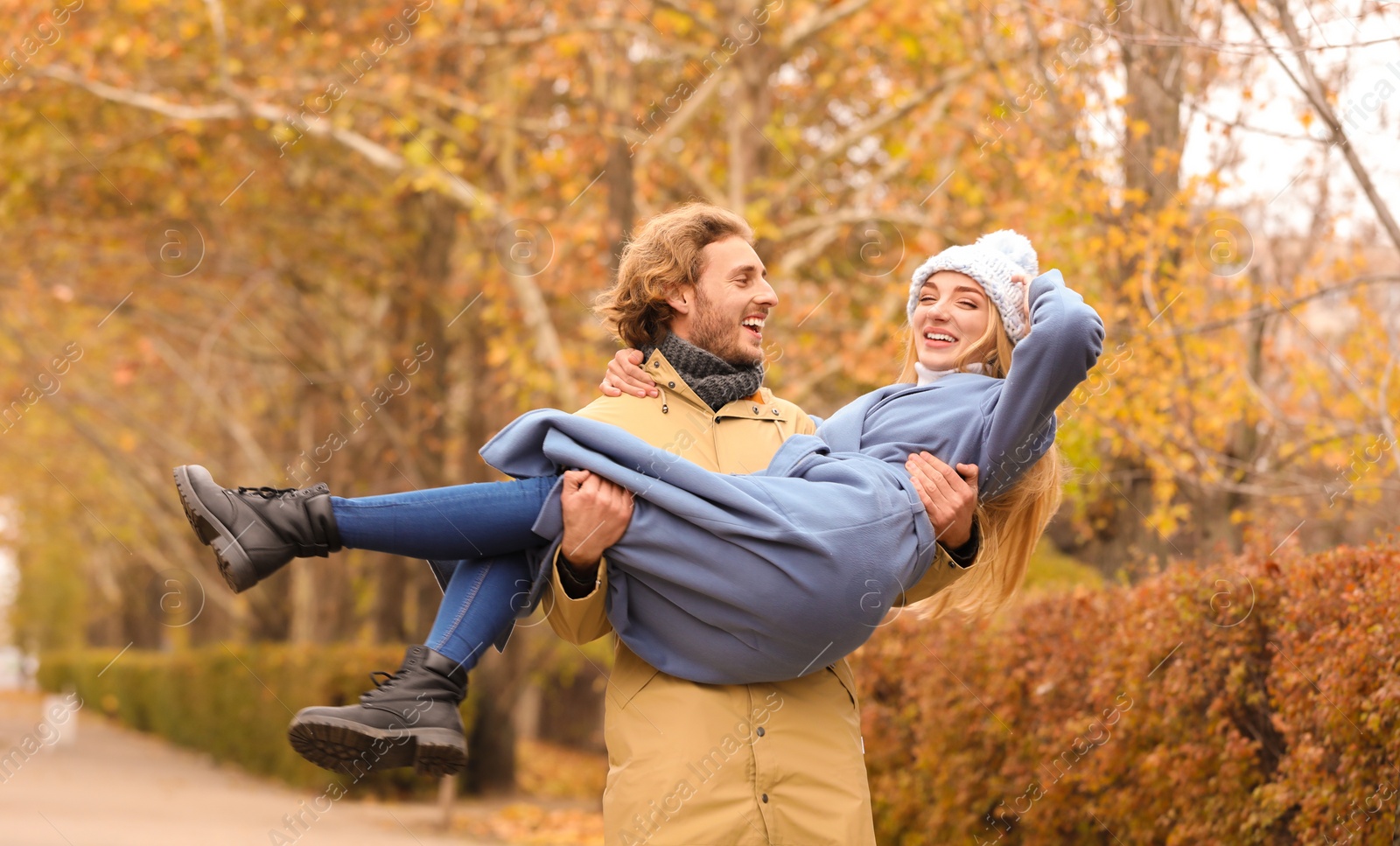 Photo of Young romantic couple having fun in park on autumn day