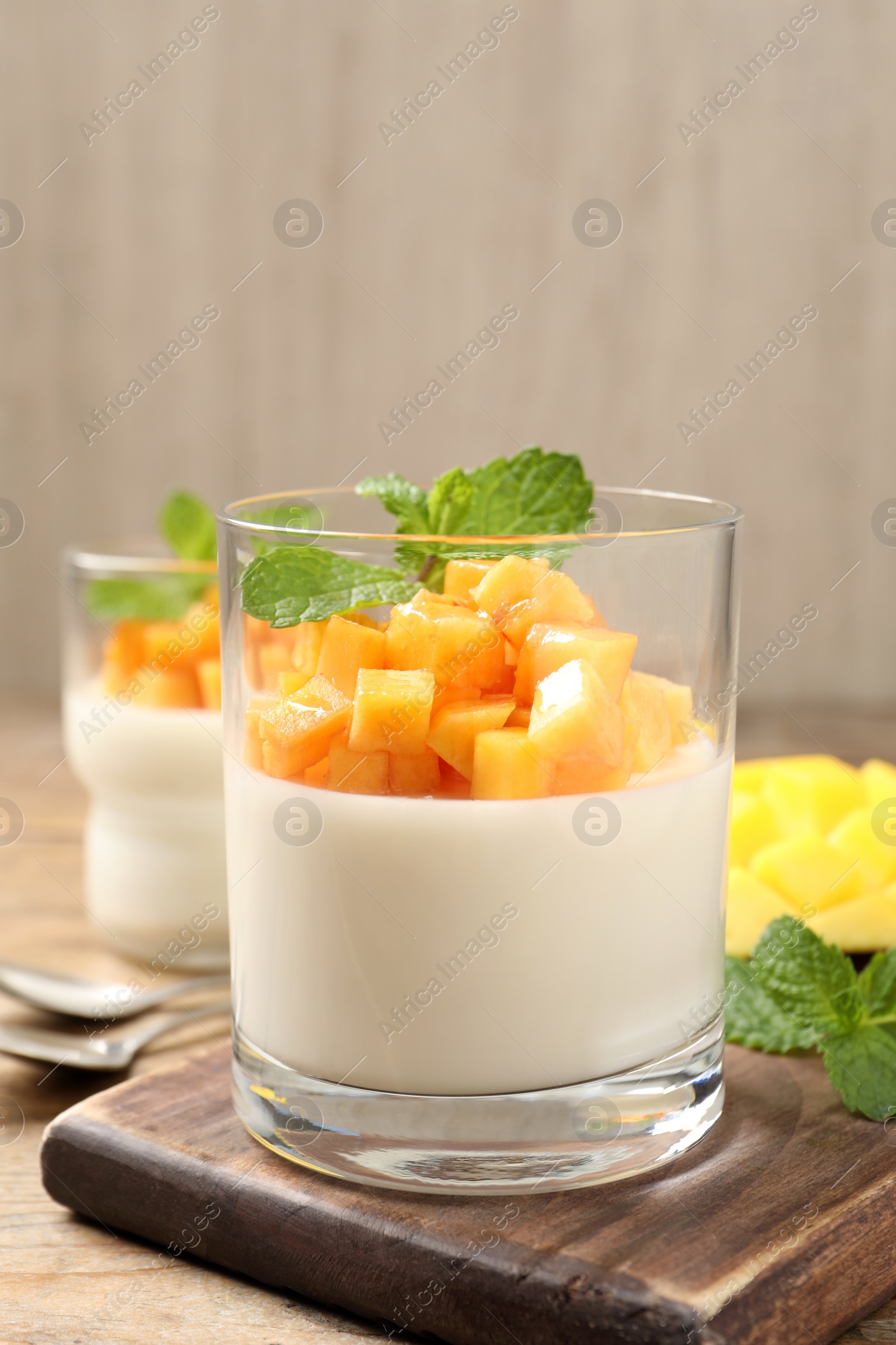 Photo of Delicious panna cotta with mango on wooden table