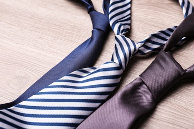 Photo of Different stylish neckties on wooden table, closeup