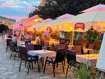 WARSAW, POLAND - JULY 15, 2022: Outdoor cafe terrace on city street in evening