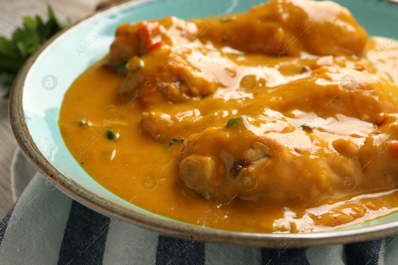 Photo of Tasty chicken curry on wooden table, closeup