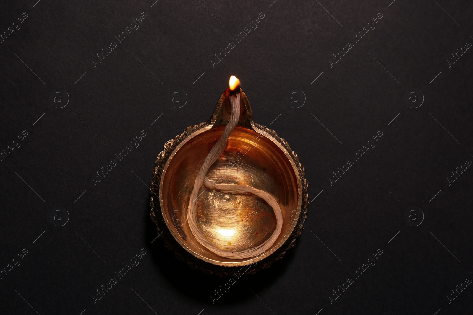 Photo of Lit diya on dark background, top view. Diwali lamp