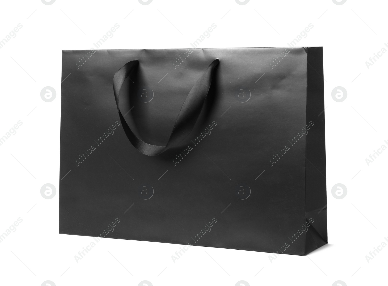 Photo of Paper shopping bag with ribbon handles on white background. Mockup for design